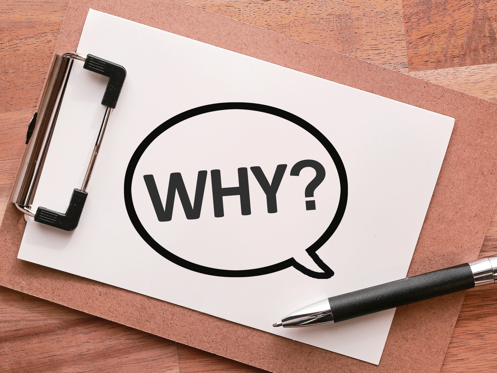 「WHY?」と書かれた吹き出しが描かれた紙