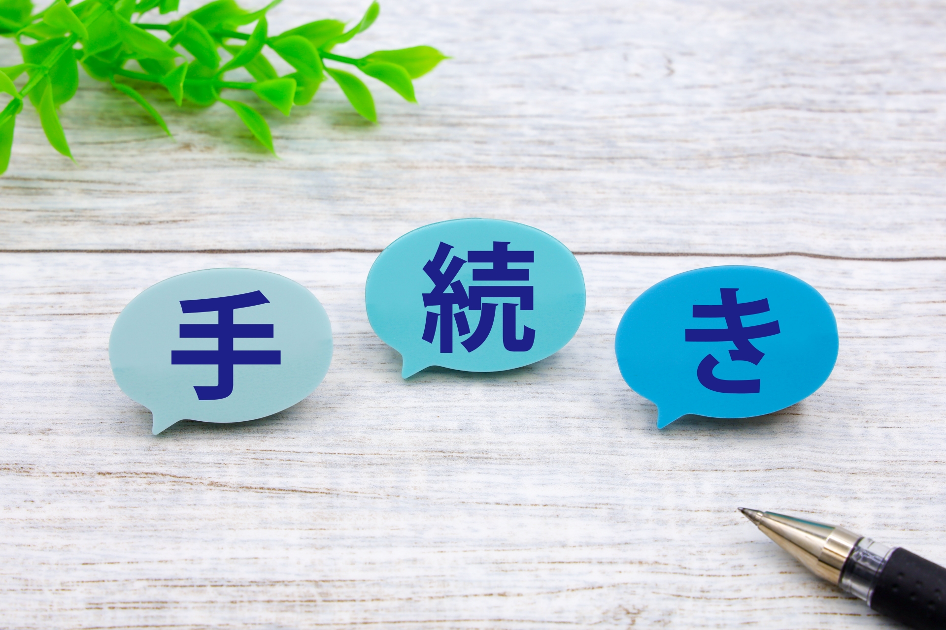 木の机の上に置かれた、日本語が書かれた3つの吹き出しとペン