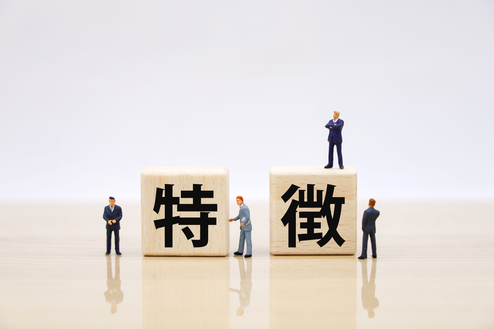 特徴と書かれたブロックとビジネスマンの人形