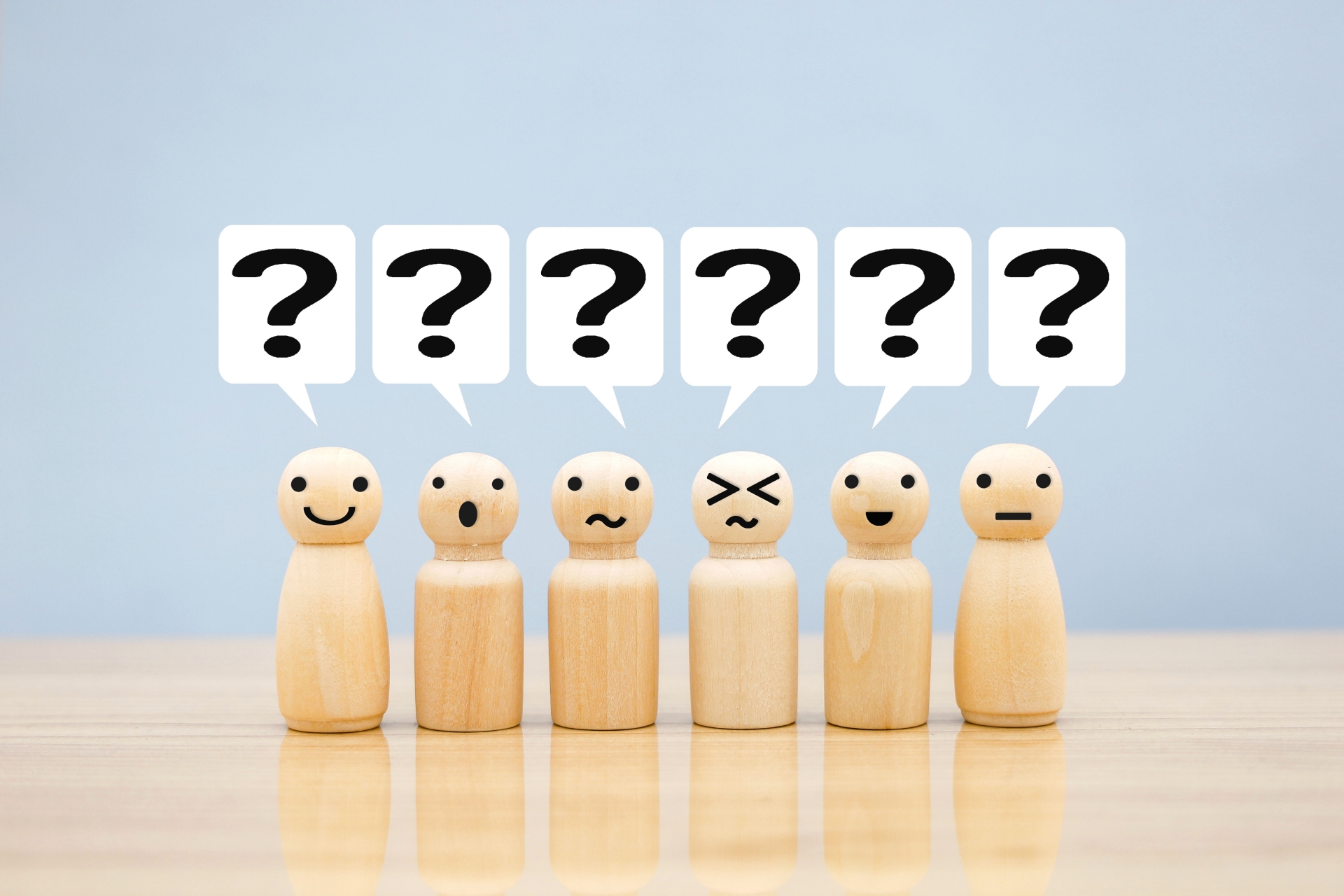疑問符を持つ様々な表情の木製の人形