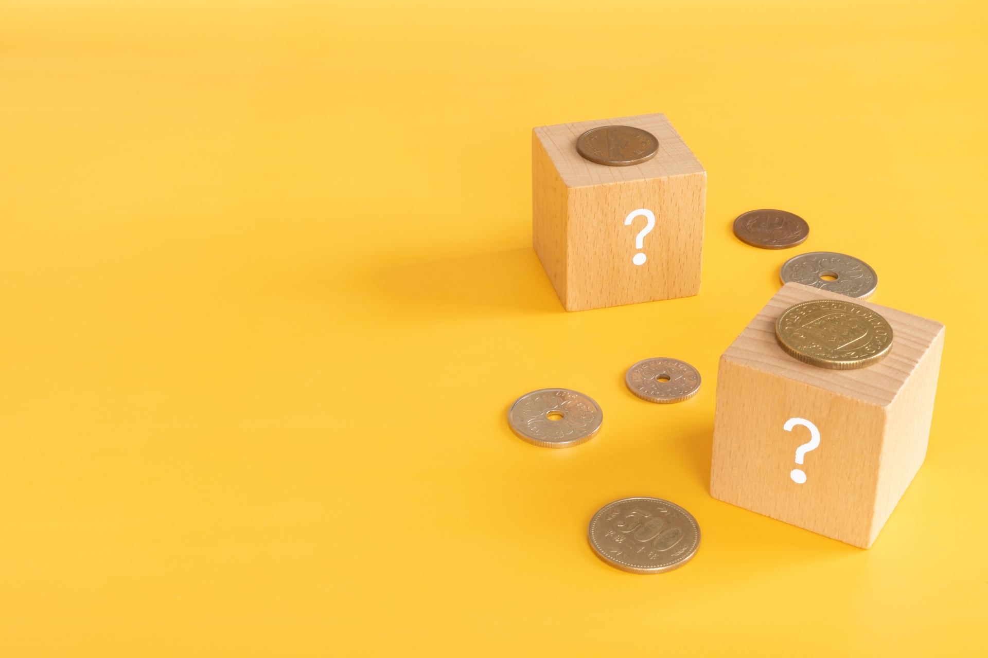 クエスチョンマークの木製ブロックと日本の硬貨