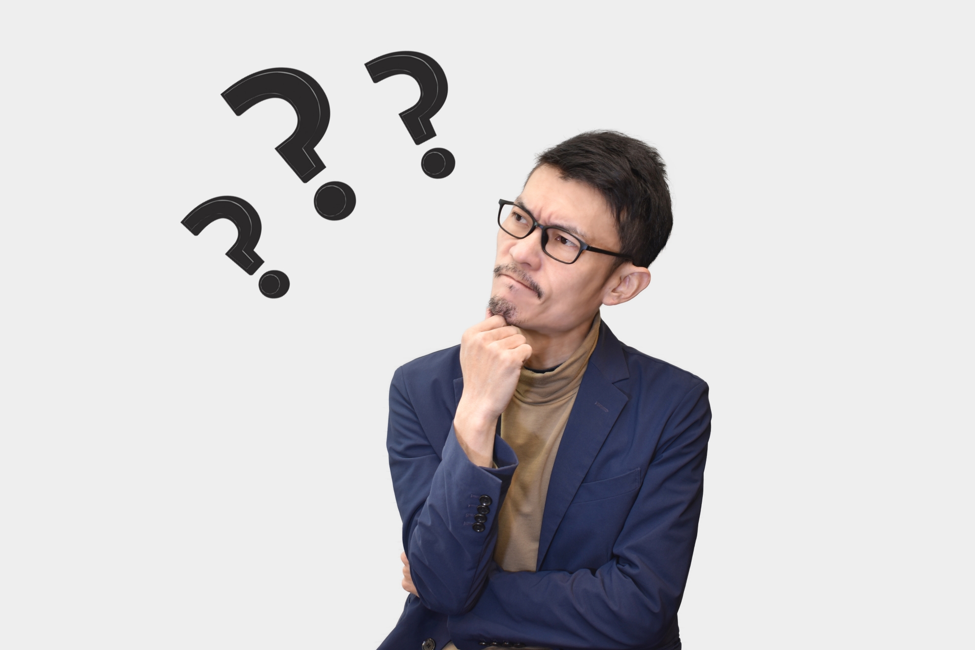 顎に手を当てて考え込む男性と疑問を表現する3つの「？」マーク
