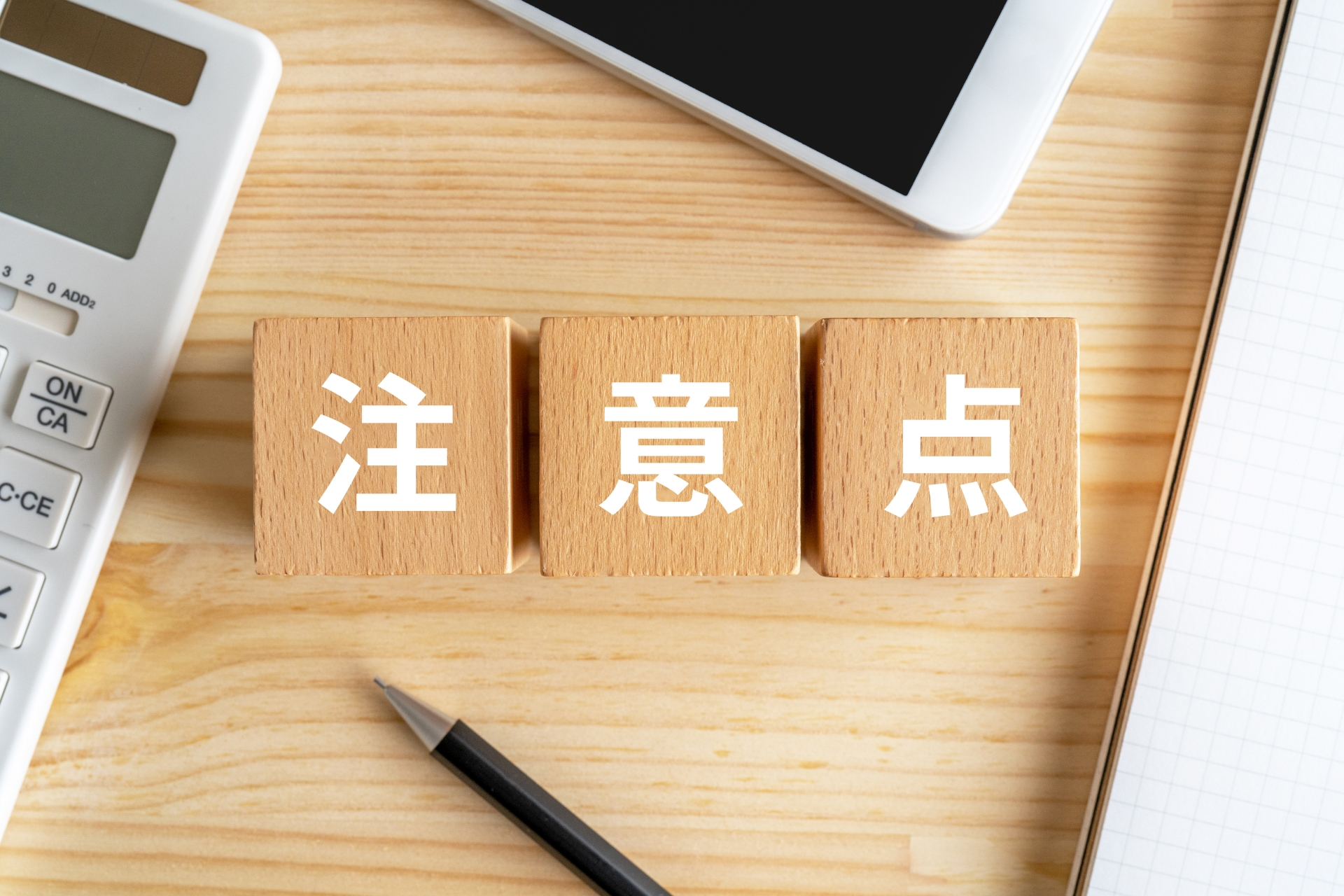 「注意点」と書かれた木製ブロックと文房具