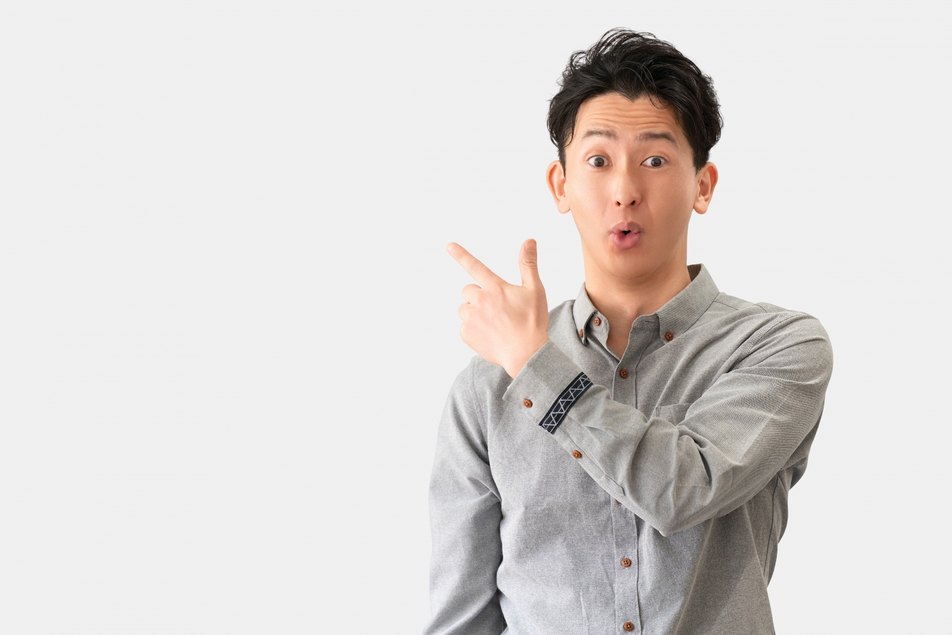 驚いた表情で何かを指差す若い男性