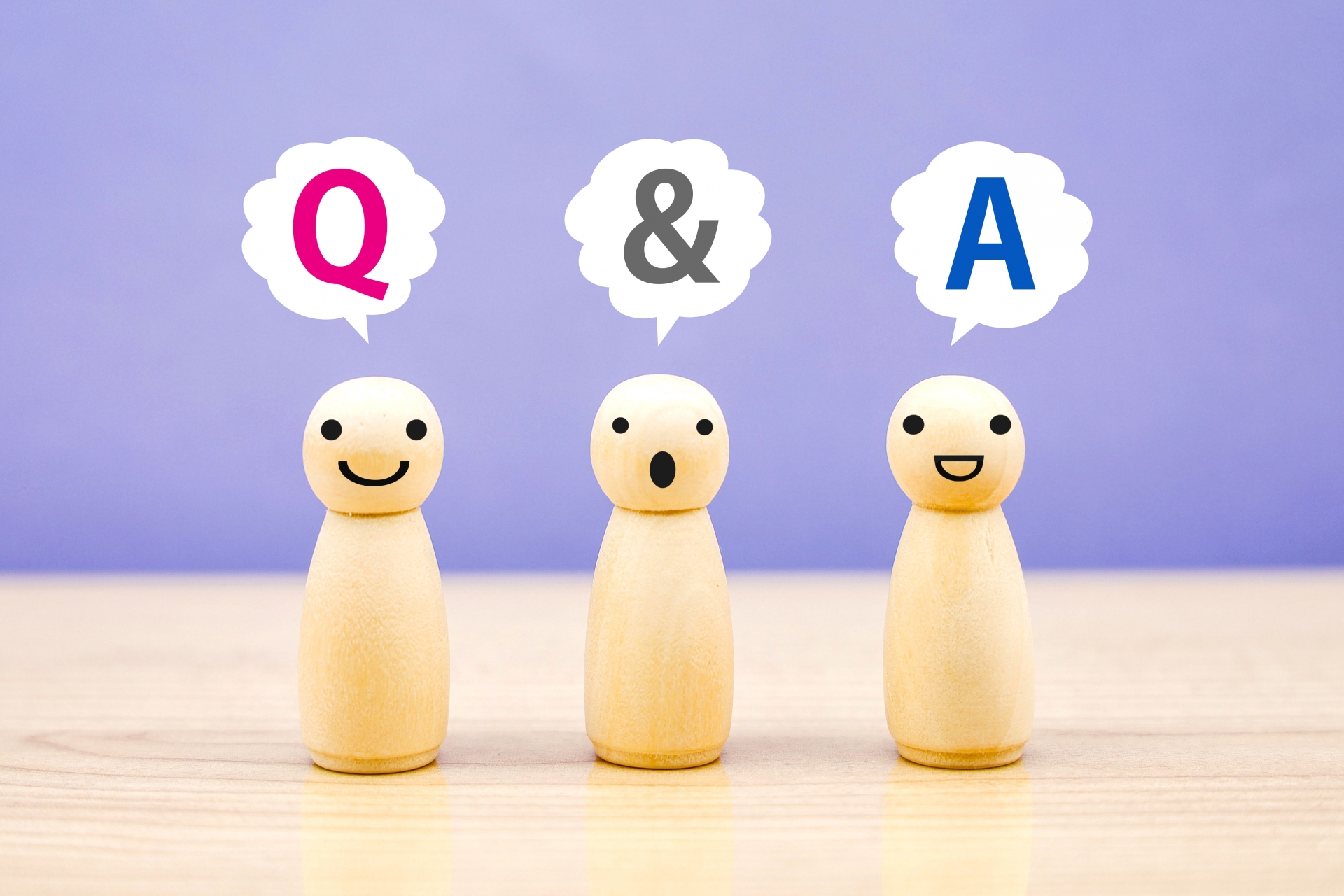 「Q & A」と書かれた吹き出しを持つ3体の木製の人形