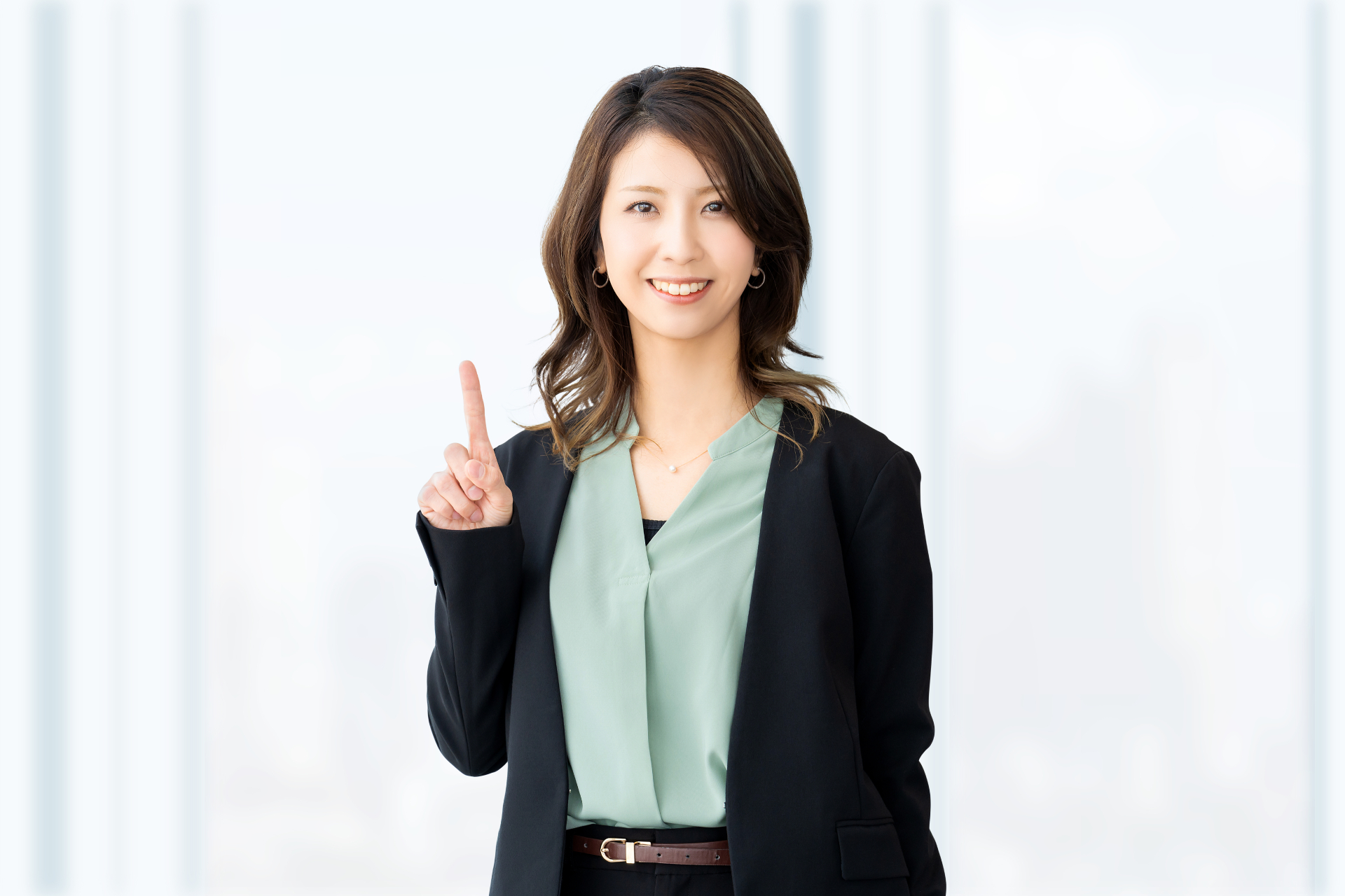 カメラに向かって指を差し、笑顔で何かを提案している様子の若いビジネスウーマン。