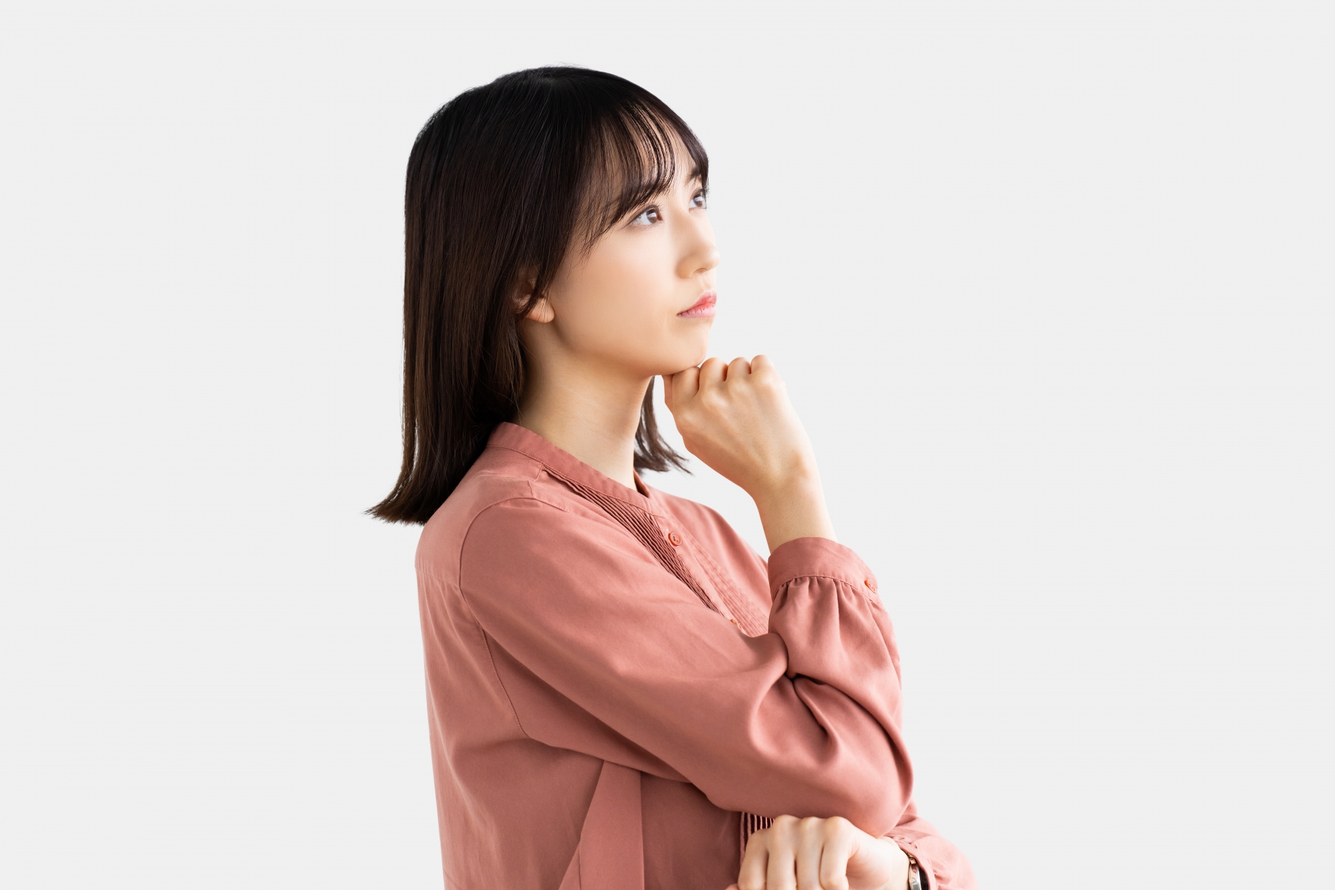 顎に手を当てて考える若い女性の横顔