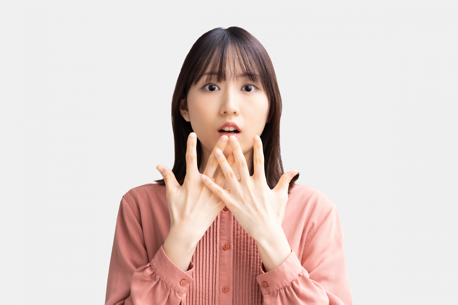 驚いて両手を口元にあてる女性
