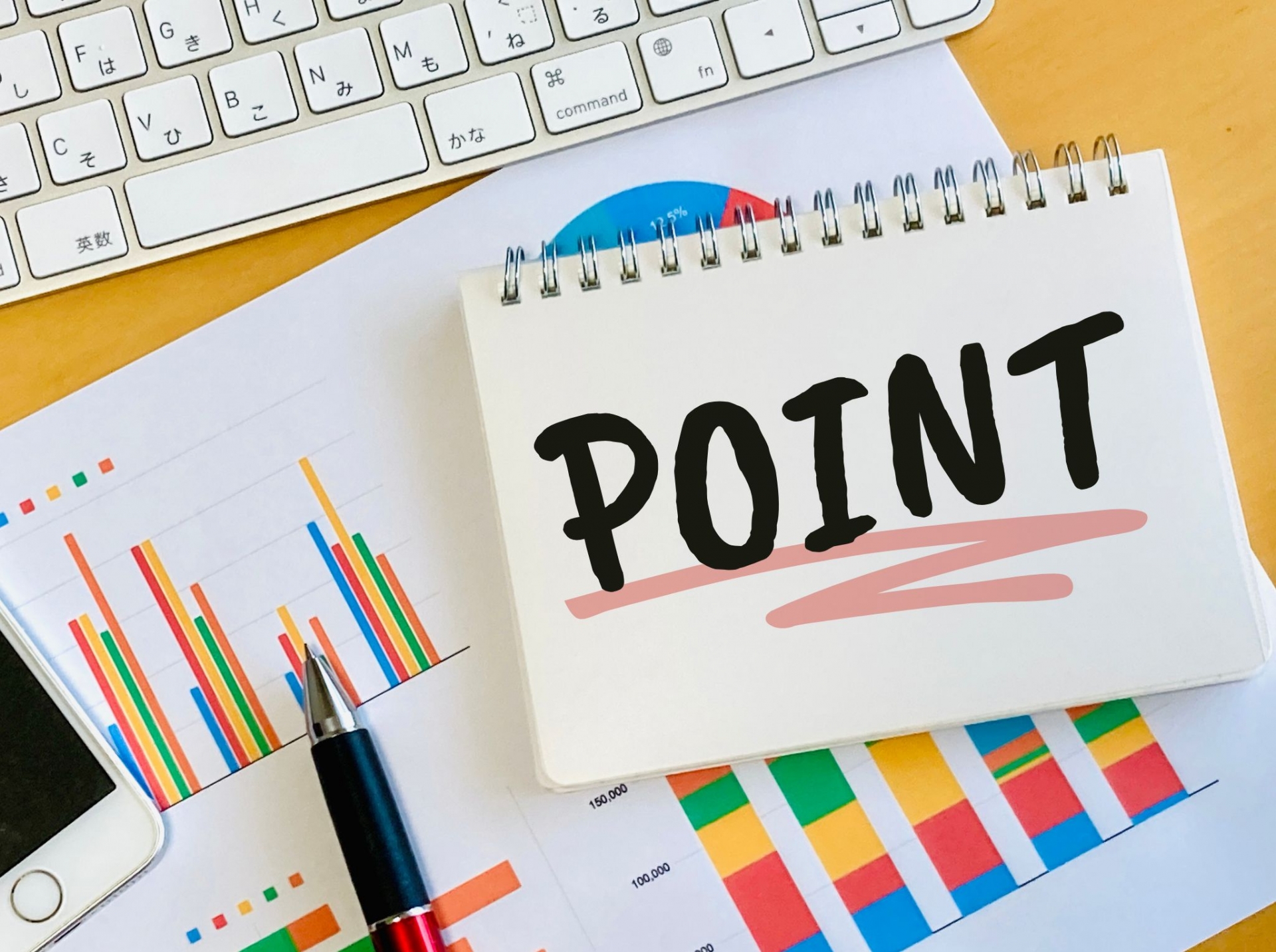 ビジネスチャートの上に置かれた「POINT」と書かれたメモ