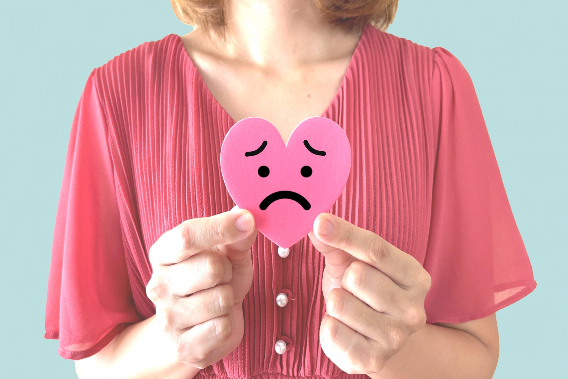 悲しい表情のハートを持つ女性