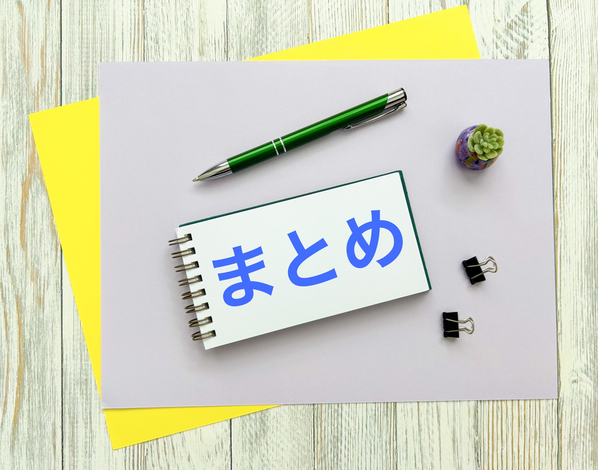 「まとめ」と書かれたノートと、ペン、クリップのイメージ