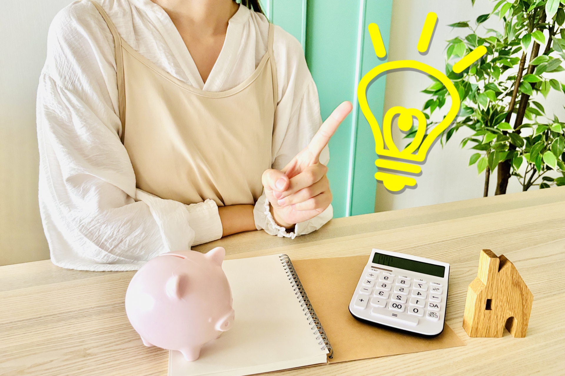 節約のアイデアをひらめく女性と、貯金箱、電卓、家の模型